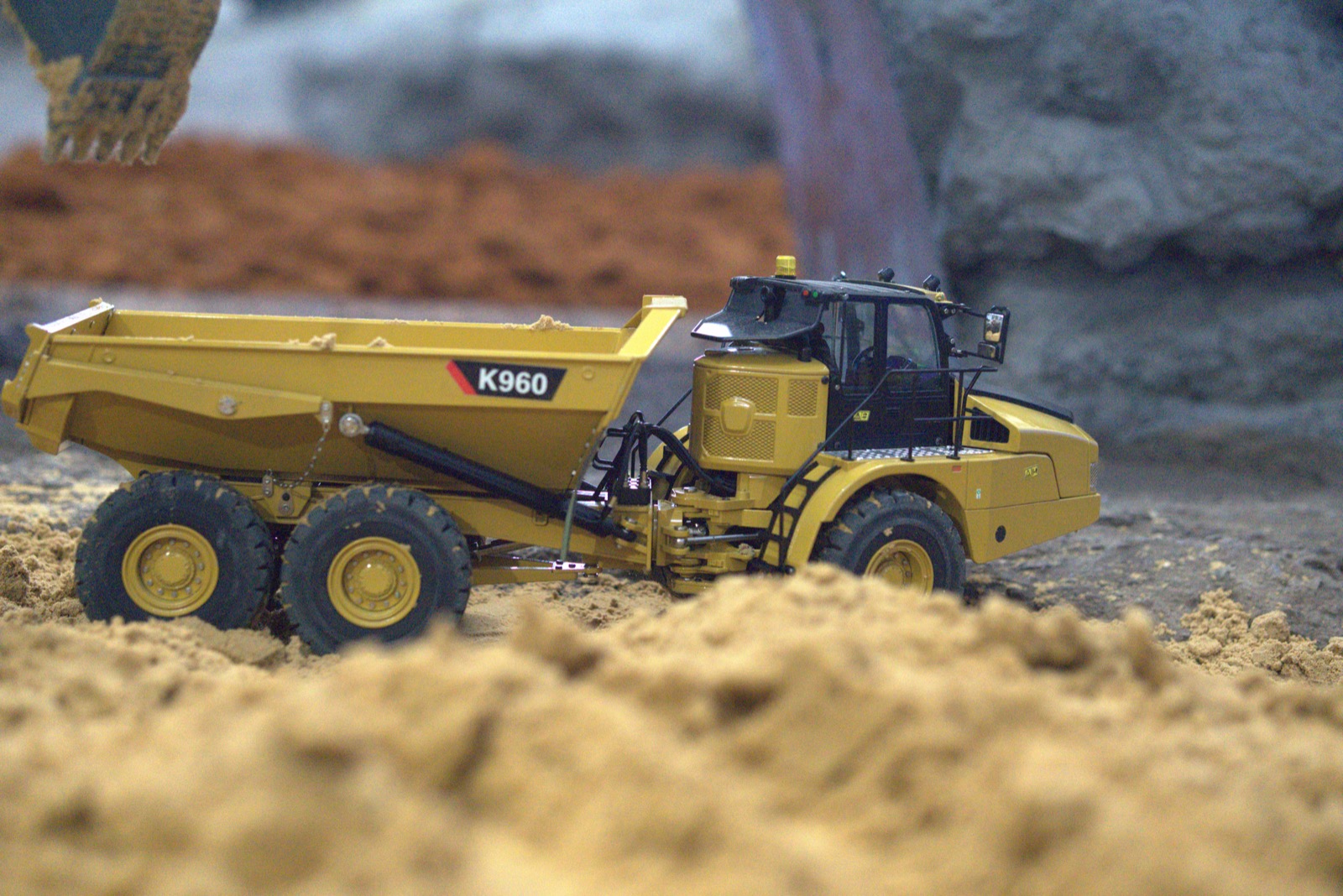 Kids driving RC construction machines in the indoor construction area at Aussie Rigs Arena